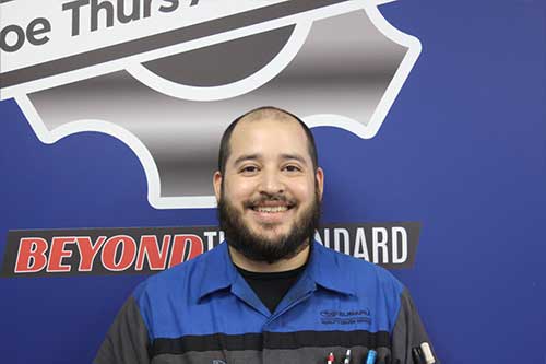 Mechanic in uniform smiling in workshop