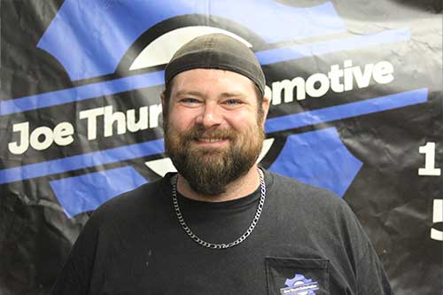 Smiling man in front of automotive banner