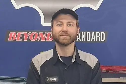 Man in work uniform sitting before blue backdrop