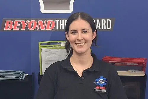 Smiling woman in branded polo at office display